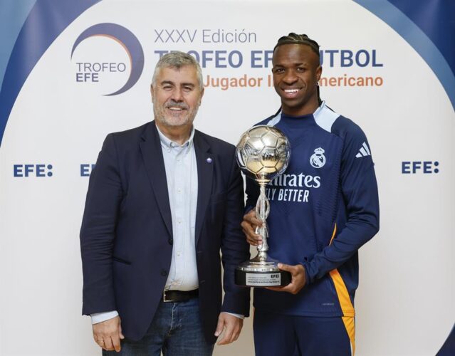 El delantero brasileño del Real Madrid Vinicius jr. (d), acompañado por el presidente de la Agencia EFE, Miguel Ángel Oliver (i), posa con el Trofeo EFE al Mejor Jugador Iberoamericano de Fútbol. EFE