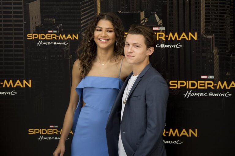 A scene from Spider Man Far From Home 2019 showing Spider-Man holding MJ in his arms in the city streets.