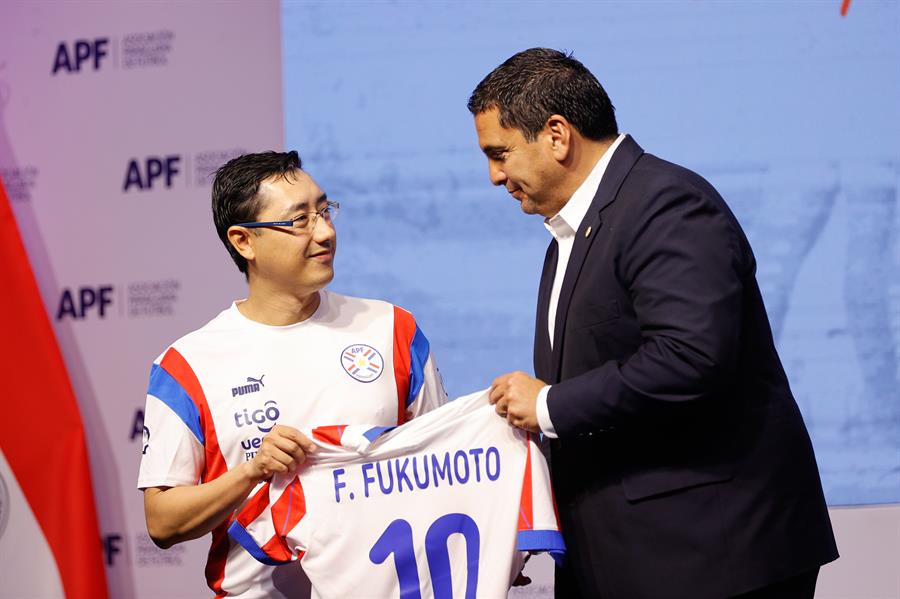 El presidente de la Asociación Paraguaya de Fútbol, Robert Harrison (d), entrega la camiseta de la selección paraguaya al nuevo director técnico, Fabio Fukumoto, . EFE/Juan Pablo Pino