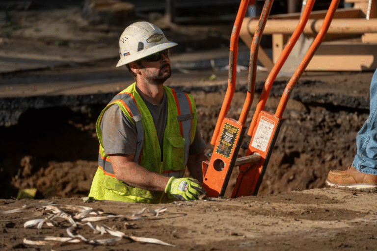 Un trabajador de la construcción sale de un hoyo mientras repara una tubería principal de agua en la intersección de Arch St. y North 1st St. en Paterson el lunes 25 de agosto de 2025. La rotura de la tubería principal se reportó el domingo 24 de agosto. Julian Leshay Guadalupe/NorthJersey.com