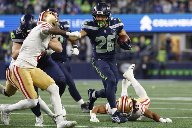 El corredor de los Seattle Seahawks, Zach Charbonnet (c), elude la marca de rivales de San Francisco 49ers durante el juego de la ronda divisiona, el 17 de enero pasado, poco antes de sufrir una delicada lesión que le hará perder el juego por el título de la Conferencia Nacional (NFC). EFE/EPA/JOHN G. MABANGLO