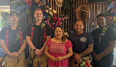 Lupita Nieves rodeada de los bomberos de New Brunswick en el restaurante Las Marias de su propiedad.