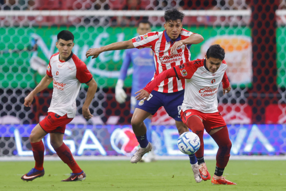 Ángel Sepúlveda (c), de Guadalajara, disputa el balón con Jesús Vega (d), de Tijuana, este sábado durante un partido del torneo Apertura 2026 de la Liga MX. EFE/ Francisco Guasco