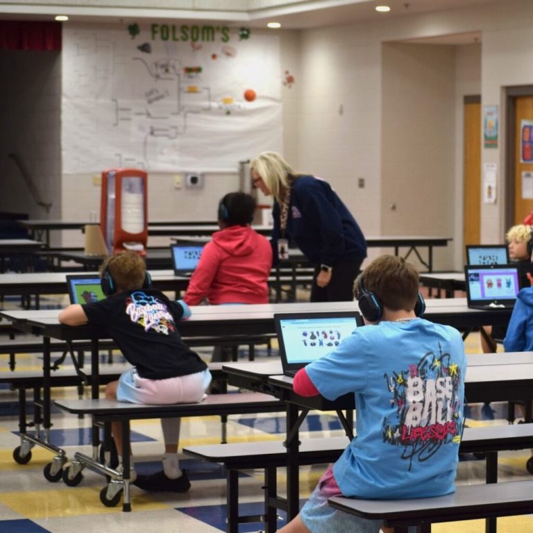 Estudiantes usan computadoras portátiles dentro de una escuela primaria en Farmington, Arkansas, el 19 de marzo de 2026. Los distritos escolares de todo el país están debatiendo en qué herramientas de inteligencia artificial invertir. (Foto de Antoinette Grajeda/Arkansas Advocate)