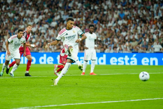 El delantero francés del Real Madrid Kylian Mbappé marca su gol de penalti en el encuentro correspondiente a la jornada 5 de LaLiga entre Real Madrid y Rayo Vallecano, este sábado en el estadio Santiago Bernabéu, en Madrid. EFE/Borja Sanchez-trillo