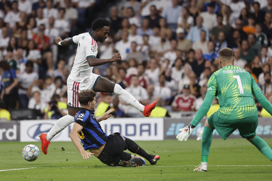 El delantero brasileño del Real Madrid Vinicius Jr. (i) intenta rematar a puerta durante el encuentro correspondiente a la Liga de Campeones que disputan Real Madrid e Inter de Milán, este martes en el estadio Santiago Bernabéu, en Madrid. EFE/Sergio Pérez