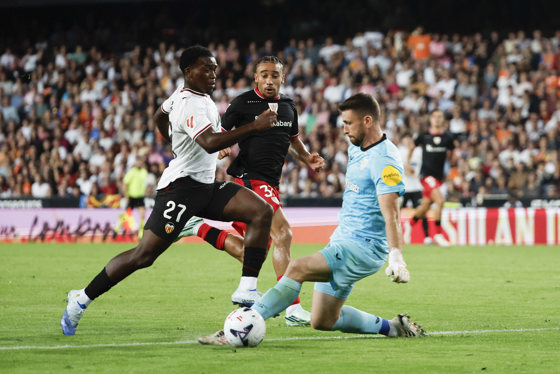 El delantero del Valencia David Otorbi (i) intenta superar a Unai Simón, guardameta del Athletic Club, durante el partido de la jornada 9 de LaLiga que Valencia CF y Athletic Club de Bilbao disputaron en el estadio de Mestalla. EFE/Manuel Bruque