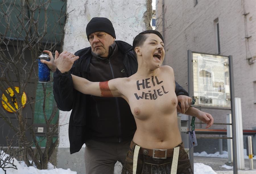 Security intervene as an activist from Ukraine's feminist group FEMEN impersonates Adolf Hitler while protesting against the Alternative for Germany (AfD) party and its leader Alice Weidel, on the day Germany holds its federal elections, outside the German embassy in Kyiv, Ukraine, 23 February 2025. EFE-EPA/SERGEY DOLZHENKO