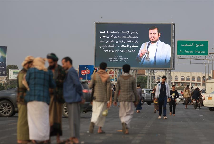 People walk by a digital billboard featuring the Houthis' leader Abdul-Malik al-Houthi, in Sana'a, Yemen, 16 March 2025. EFE-EPA/YAHYA ARHAB