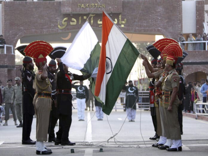 Indian Border Security Force (BSF) soldiers and Pakistan Rangers soldiers (in black) lower their respective countries flags after the Beating The Retreat ceremony at the India-Pakistan joint check post at Attari about 30 kms from Amritsar, India. EPA/EFE/RAMINDER PAL SINGH