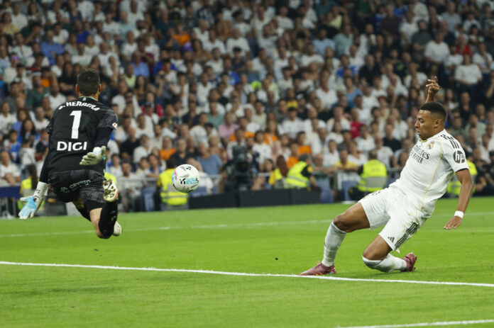 Real Madrid's French striker Kylian Mbappé (right) attempts a shot during the LaLiga match between Real Madrid and Atlético Osasuna on Tuesday at the Santiago Bernabéu Stadium. Aug. 19, 2025. EFE/Mariscal