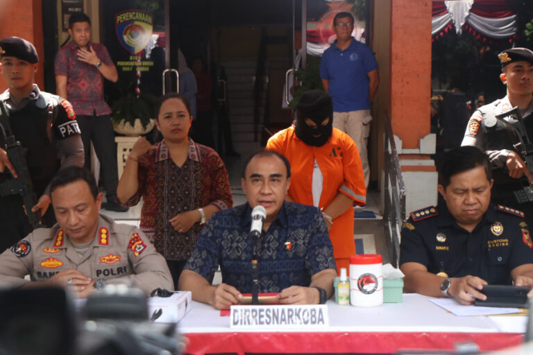 A handout photo shows police and a Peruvian woman (orange jumpsuit) who was arrested at Bali airport with 1,432.87 grams of cocaine at a press conference on Aug. 19, 2025. EFE/Bali Police Narcotics Unit
