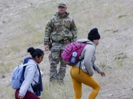 (FILE)- Un miembro de la Guardia Nacional de Texas (C) observa cómo los migrantes suben la colina en Shelby Park, en Eagle Pass, Texas, EE. UU., el 21 de diciembre de 2023. EFE/EPA/Adam Davis