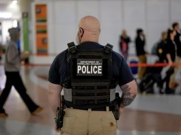 A Department of Homeland Security federal police officer stands watch as air passengers wait in long security screening lines to pass through a Transportation Security Administration (TSA) checkpoint at HartsfieldJackson Atlanta International Airport in Atlanta, Georgia, US, 19 March 2026. EFE/EPA/ERIK S. LESSER