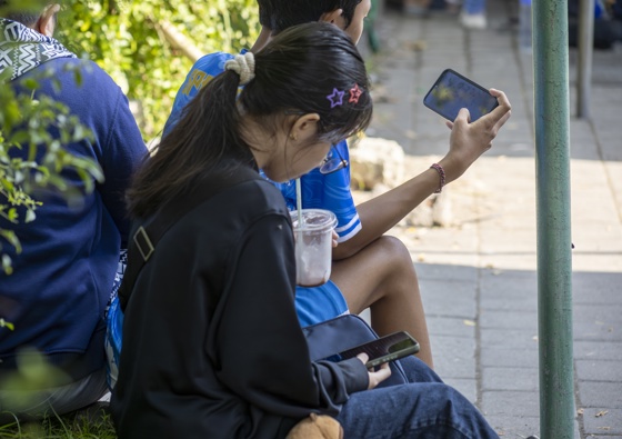 People use mobile phones at a park in Denpasar, Bali, Indonesia, 28 March 2026. EFE/EPA/MADE NAGI