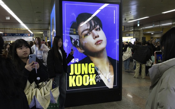 A fan poses with band member JungKook's ad as they gather to see a concert of K-pop group BTS, also known as ARMY, in Goyang, northwest of Seoul, South Korea, 09 April 2026, where BTS is kicking off its new world tour 'Arirang.' EFE/EPA/JEON HEON-KYUN