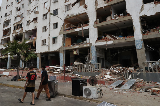 People walk past buildings damaged by the earthquakes in the Caraballeda area of ​​La Guaira, Venezuela, this Saturday. EFE/Raúl Martínez