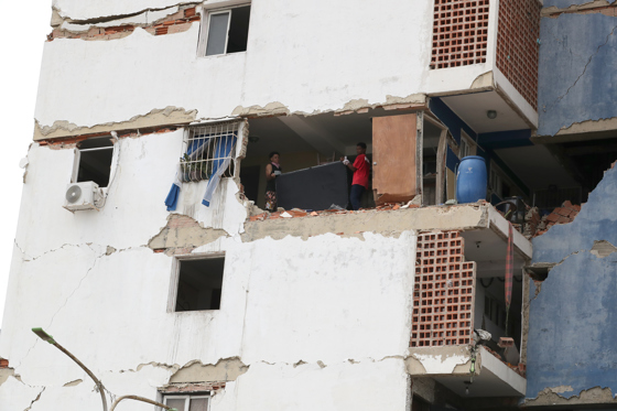 People remove their belongings from a building damaged by the earthquakes in the Caraballeda area of La Guaira, Venezuela, on Saturday. EFE/Raúl Martínez