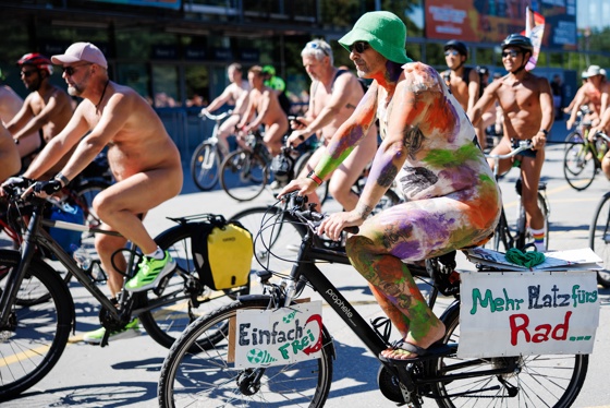 A participant wearing body paint displays signs on his bicycle that read 'Simply free' (L) and 'More space for the bike' during the World Naked Bike Ride Berlin, in Berlin, Germany, 09 August 2026. EFE/EPA/CLEMENS BILAN ATTENTION: NUDITY